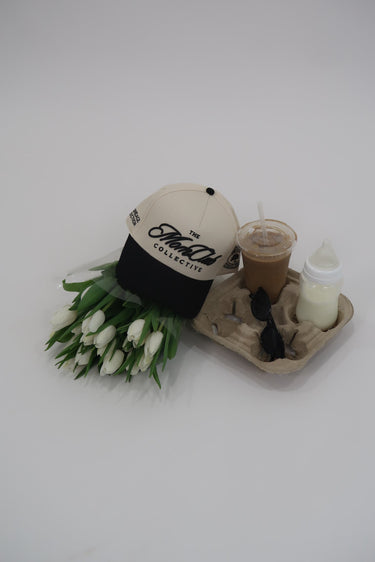 Mom Club Collective hat, bouquet of tulips, and coffee on a tray with a white background