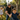 Man pushing a child on a swing with two children running in the background in a park.