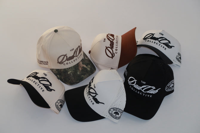 Collection of hats with 'The Dad Club Collective' logo on a white background