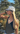 Woman wearing a cap and black tank top with a scenic background