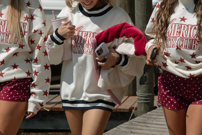 Three people wearing American Sports Club sweatshirts