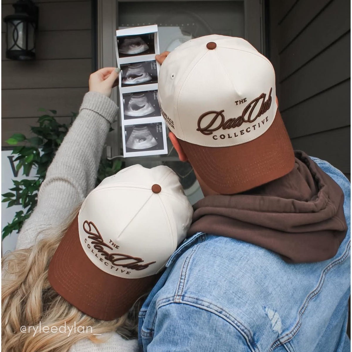 Two people wearing 'The Dad Club Collective' hats looking at ultrasound images.