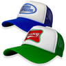 Two trucker hats, one with a blue brim and white crown featuring the text 'STAY GROOVY', and the other with a green brim and white crown featuring a red and white logo.