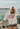 Person wearing a 'American Icons Club' sweatshirt on a boat with water and sky in the background