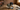 Collection of hats with 'Cowboy' and 'American Western Club' branding on a wooden floor with a brick wall background.
